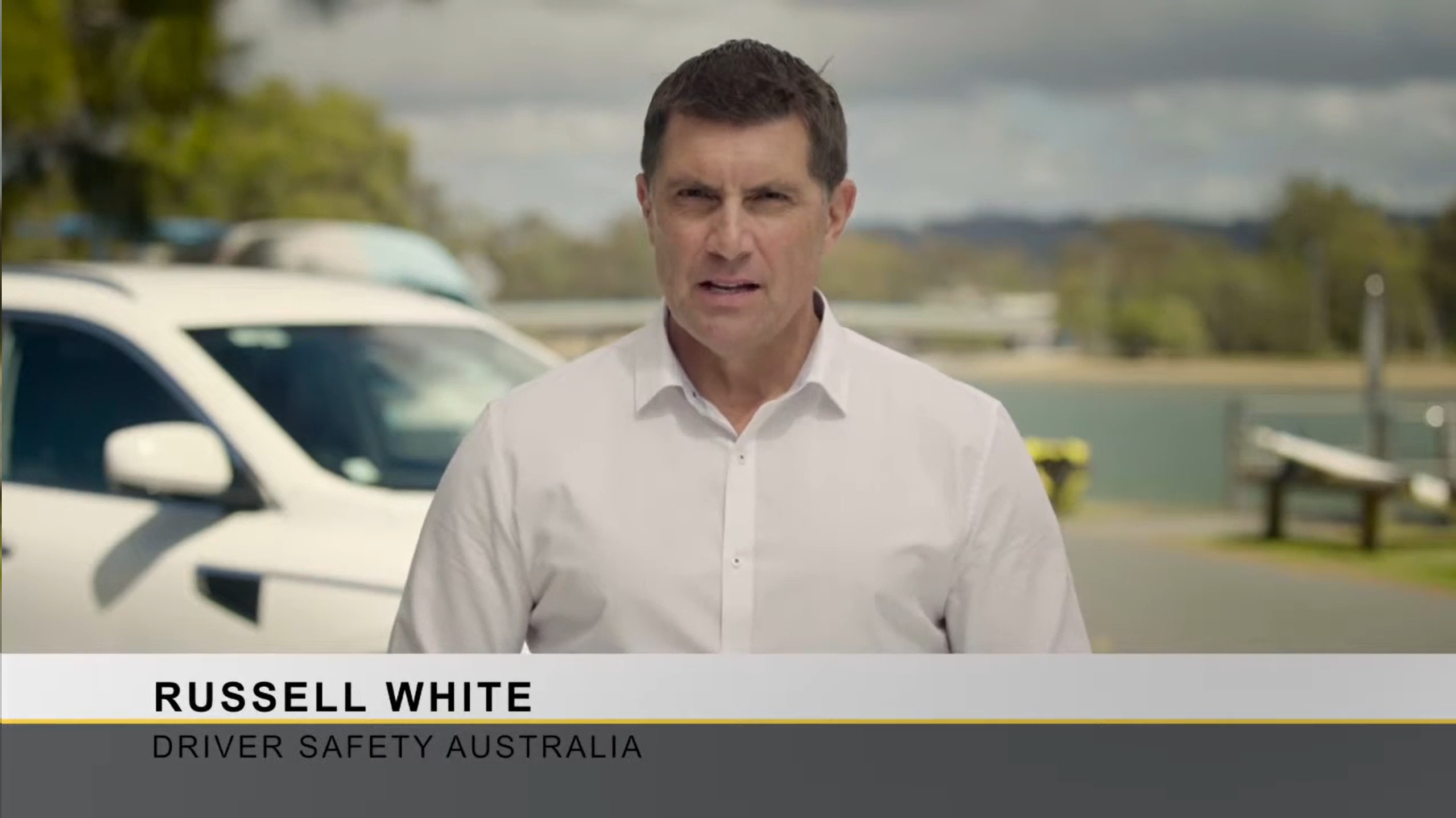 man standing in front of a car giving a presentation