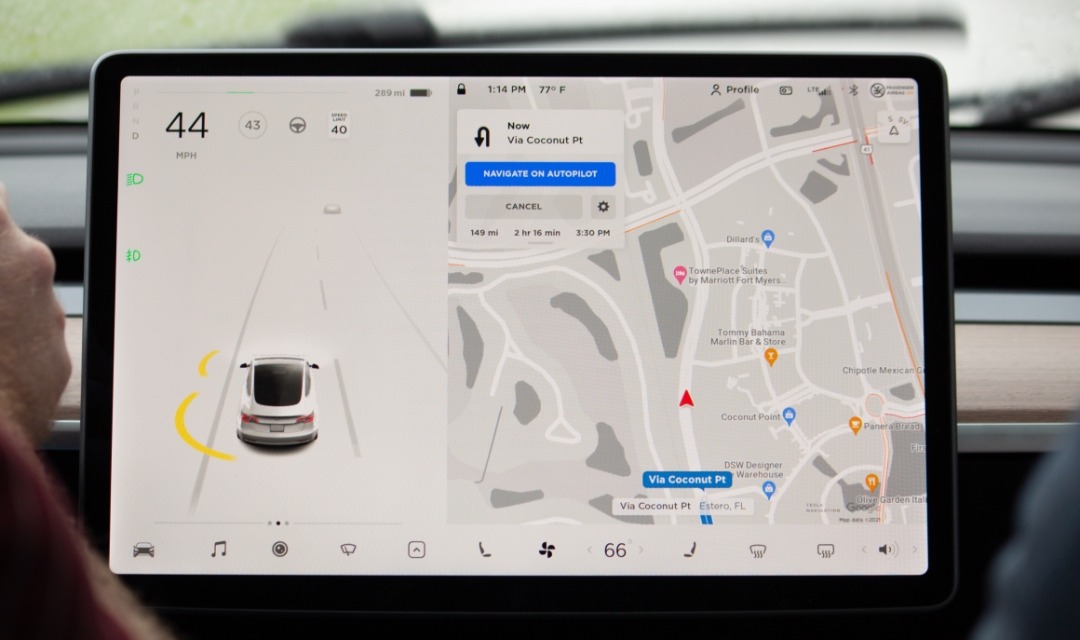 Tesla Model 3 display screen showing Autopilot with car icon and map of driving location