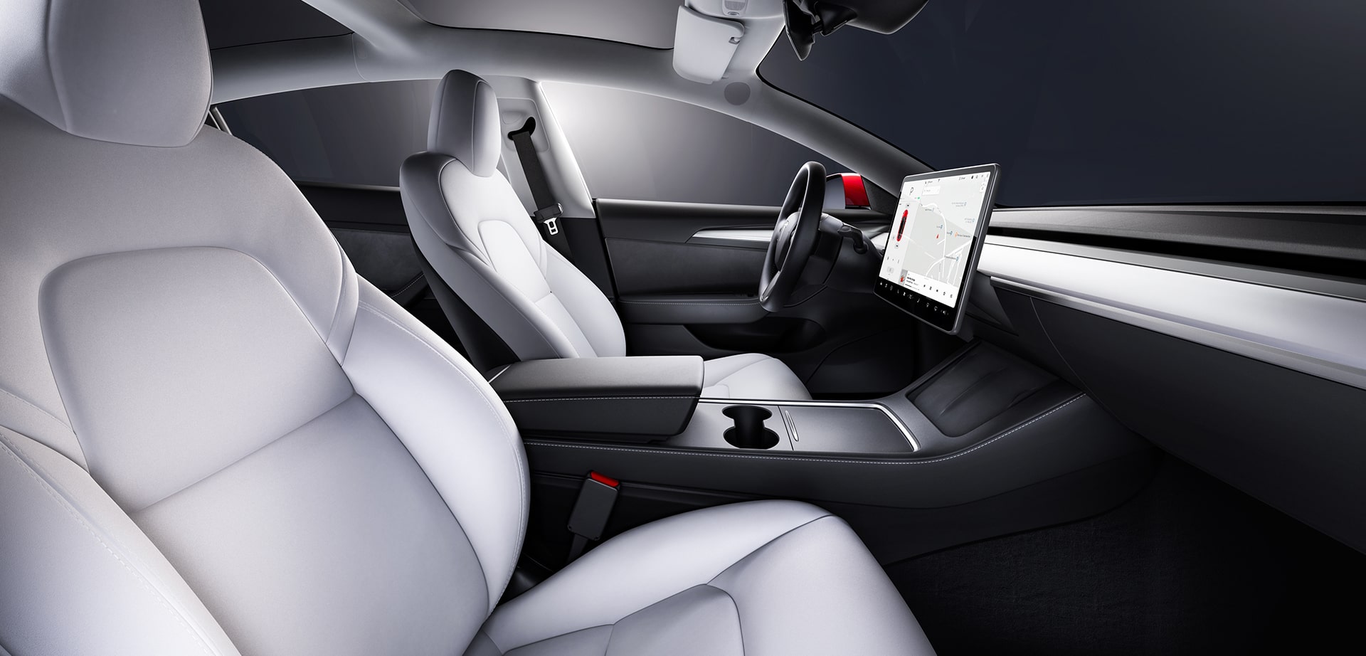 Interior side view of Tesla car's front seats with visible steering wheel and display screen